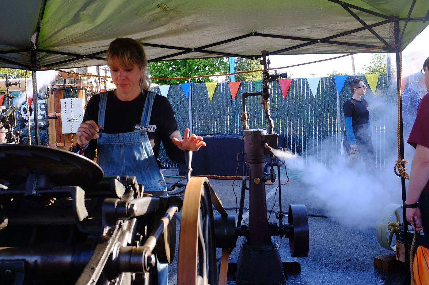 Printer operating a steam-powered letterpress at an outdoor fair