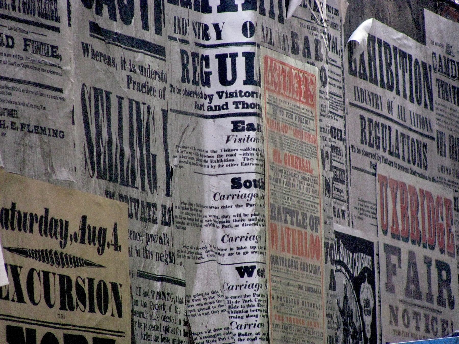 Wall layered with torn vintage letterpress posters and bold type